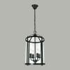 The Manor 4lt pendant is a black metal fixture with a clear cylindrical glass shade, featuring four candle-style bulbs and an elegant chain suspension.