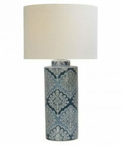 The Marco Polo table lamp has a cylindrical blue ceramic base with a white floral pattern and is topped with a large, round white lampshade.