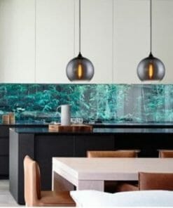 Modern kitchen with black island, brown chairs, nature-inspired backsplash with green plants, and Chuva Series pendant lights.