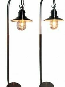 Two identical Lantern floor lamps with exposed bulbs and metal cage covers stand side by side on round bases, bringing an industrial style to any room.