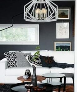 A modern living room featuring a white sofa, black and patterned cushions, round coffee tables, Gamba Series pendant lights, dark walls, and framed artwork.
