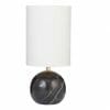 The Palazzo Table Lamp - Black showcases a round black marble base with bold white veining and a tall cylindrical white shade, offering timeless elegance.