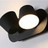 A sleek black Yarra LED Wall light (Duo) with a cylindrical shade emits bright light against a white background.
