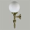 The Vattimo 1Lt wall sconce showcases an ornate brass base and a round white glass globe shade, set against a light gray background.