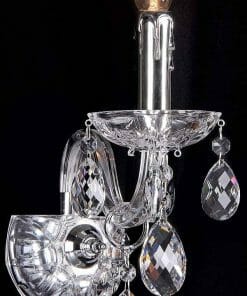 The Venice 1Lt wall light showcases a candle-style bulb with multiple hanging crystal ornaments, all set against a sleek black background.
