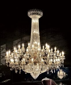 The Asfour crystal 6000 - 47" 51 Light chandelier features multiple tiers and 51 candle-style lights, glowing against a dark background with a chair partially visible below.