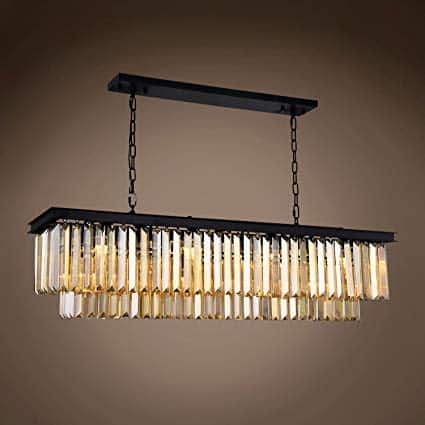 The Odeon 12 light pendant is a rectangular black metal chandelier with hanging rows of gold-tinted crystal prisms, suspended by two chains.