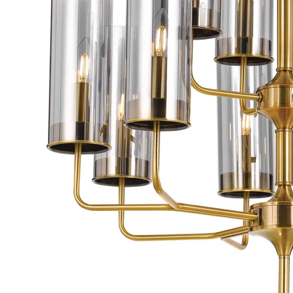 Close-up of the Decrola 12 light pendant featuring gold metal arms and cylindrical glass shades that encase exposed bulbs.
