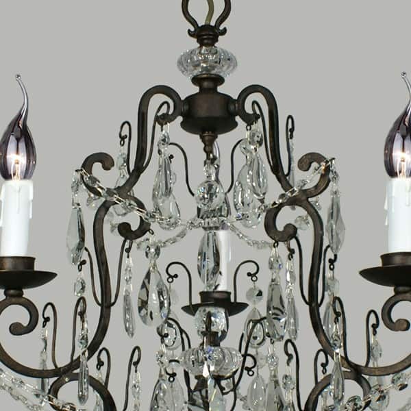 Close-up of the Salzburg 3 crystal chandelier featuring black metal arms, glass crystals, and illuminated candle-shaped bulbs against a plain gray background.
