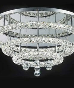 The Horos C-7548 crystal CTC ceiling chandelier features three circular, crystal-encrusted tiers and hanging crystal pendants, set against a black background.