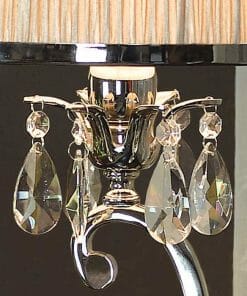 Close-up of the Luxuria 1 light table lamp with a metallic base, crystal pendants, and a beige pleated shade.