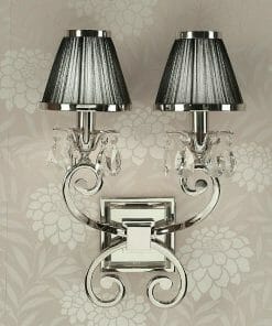 The Luxuria 2 light wall sconce showcases a sleek silver double design with black shades and crystal accents, creating an elegant look against floral-patterned wallpaper.