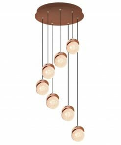 The Saturn 1 pendant features seven spherical glass globes suspended at different lengths from a round base, each partially wrapped in a copper-colored band for a modern look.