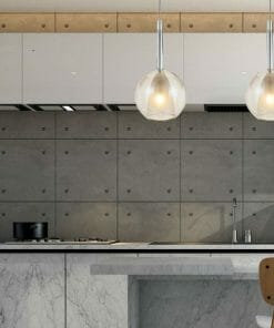 Modern kitchen with a gray concrete backsplash, white cabinets, marble countertop, and two Lapin 1 pendant smoke lights above a bar paired with a wooden chair.