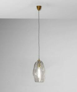 The Organic large pendant hangs from the ceiling by a cord, featuring a clear glass shade and visible bulb against a plain gray wall.