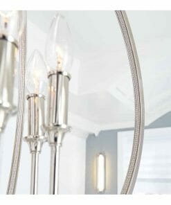 Close-up of the Corinne 3 small light fixture with three candle-style bulbs in a modern chrome finish, shown against a white ceiling and light grey walls.