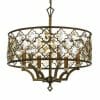 The Mimosa 6 is a brass chandelier featuring an ornate lattice-style drum shade and candle-like bulbs inside, suspended by a chain for elegant illumination.