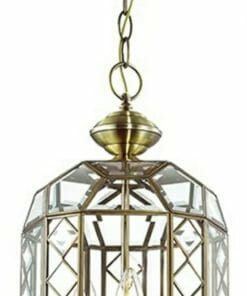 The Errolant 1 brass pendant light features a faceted glass shade, hangs from a chain, and displays three candle-style bulbs inside.