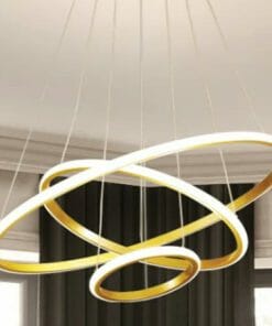 The Tuscan 3 Ring Black chandelier showcases interlocking black and gold rings suspended by wires, creating a modern statement against a neutral interior backdrop.