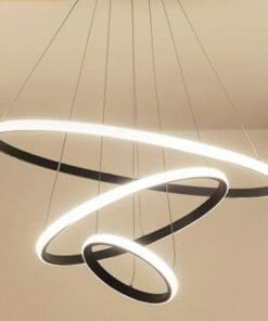Three modern Tuscan 3 ring black LED pendant lights of different sizes hang in a spiral from the ceiling against a neutral background.
