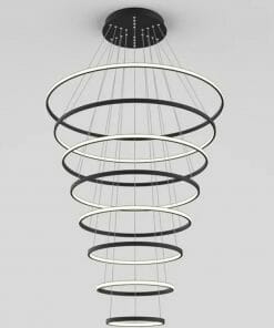The Tuscan 8 Ring Chrome chandelier features eight circular LED rings of varying sizes, suspended in a spiral by thin cables, combining sleek chrome finish with modern elegance.