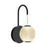The Langton 1 gold is a wall-mounted light featuring a black curved arm and a round, textured, glowing lampshade.