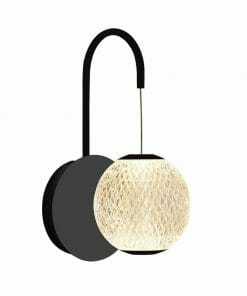The Langton 1 gold is a wall-mounted light featuring a black curved arm and a round, textured, glowing lampshade.