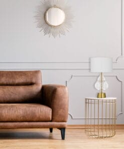 Elegant living room with mirror, sofa, and table lamp