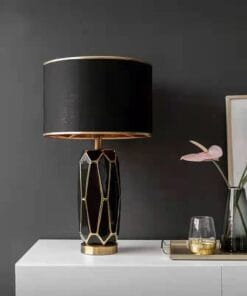 Elegant black and gold table lamp on white sideboard